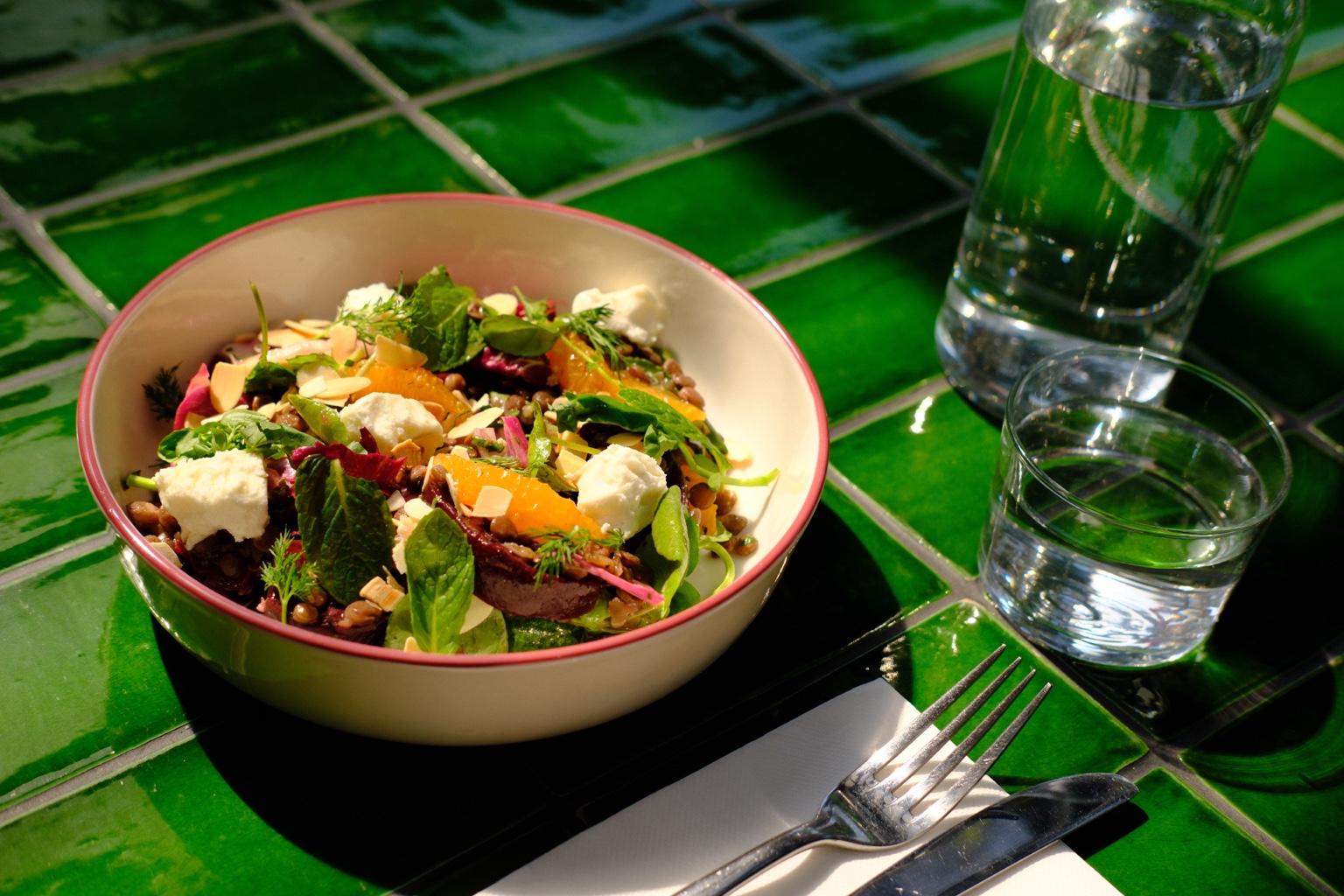 A fresh seasonal salad on CALI JARDÍN's green tiled table