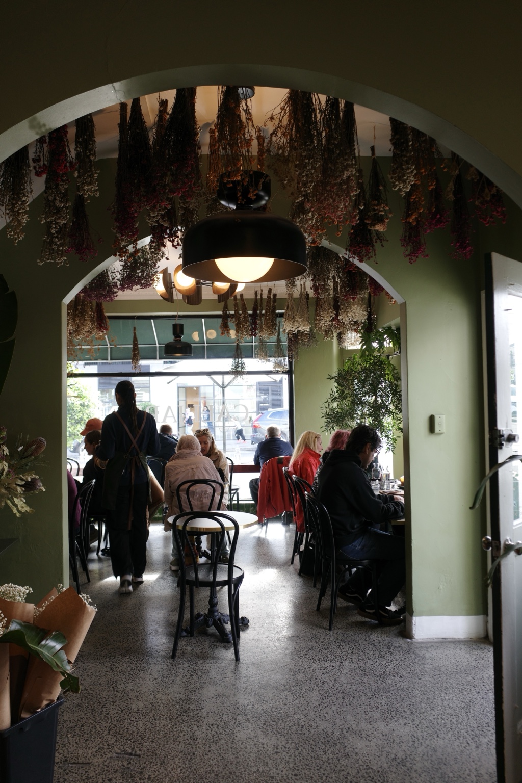 The dining room at CALI JARDÍN, framed by flowers and green arches